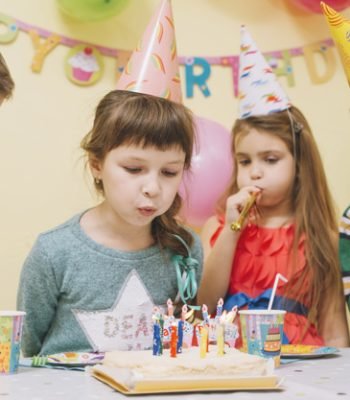 kids-blowing-candles-cake_23-2147773150